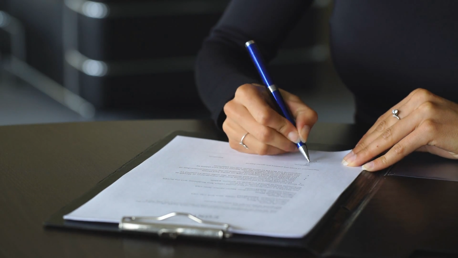 Top 6 Considerations for Navigating Employee Terminations in Ontario: A Comprehensive Guide for Employers 3 womans hand with pen signing document close up