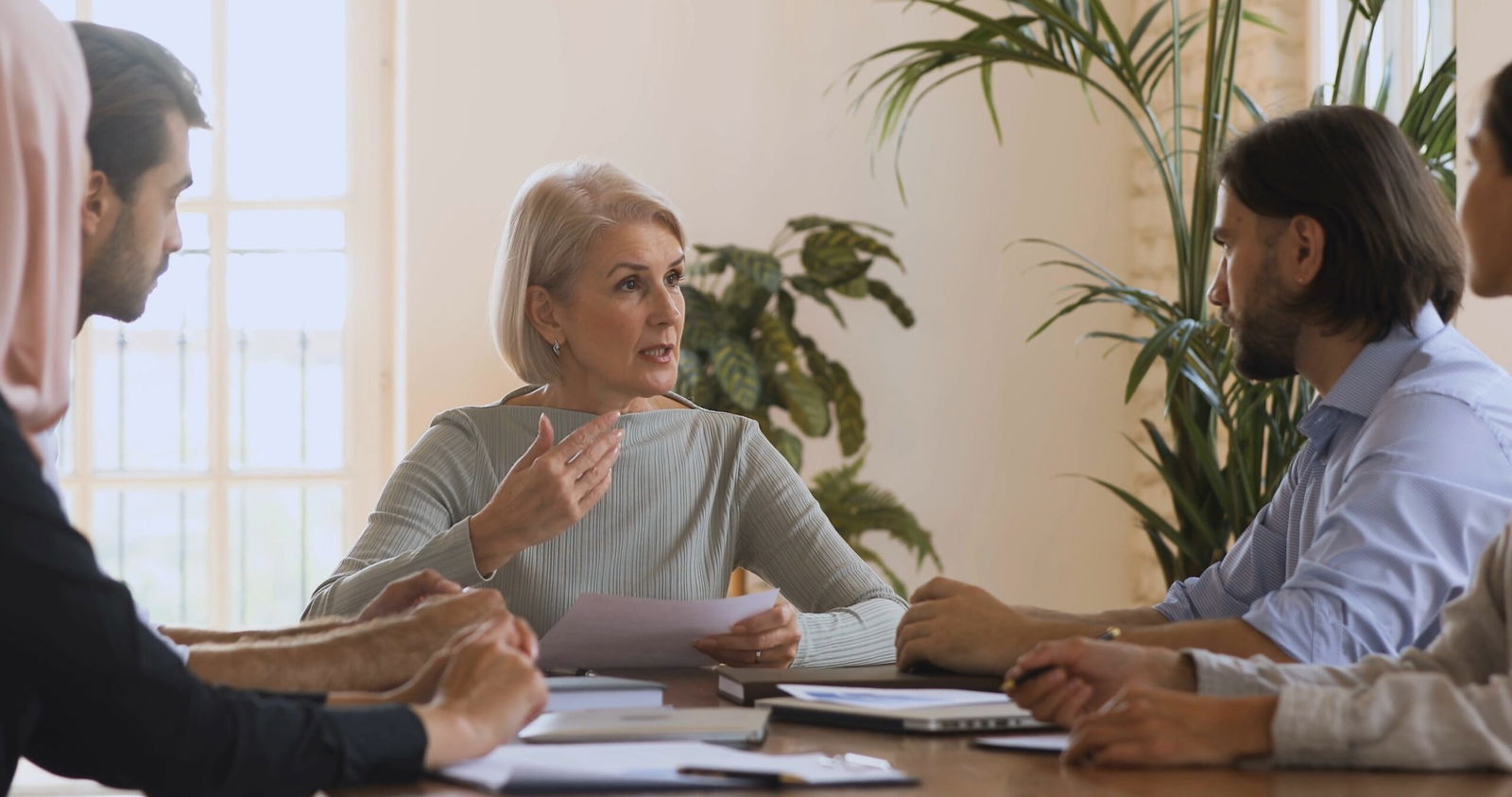 Building a Fair Workplace Investigation Process: Best Practices for Employers 2 01 serious older female leader talking to team people discussing paperwork SBV 338137696 4K 00.00.01.360 scaled