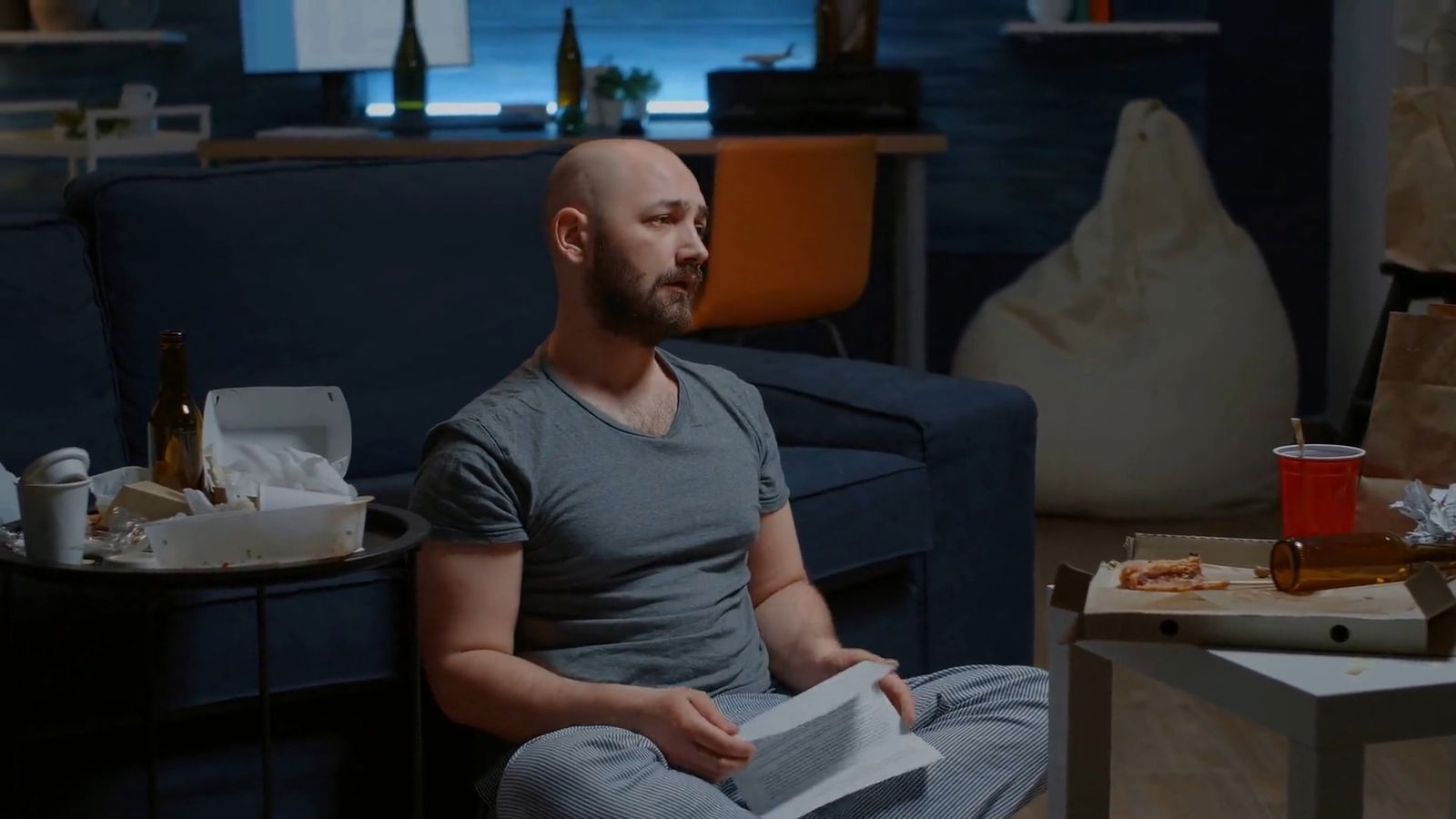 The Closure Letter: What Employers Need to Share After a Harassment Investigation 5 Man sits in his apartment upset and finally relieved at receiving his closure letter.